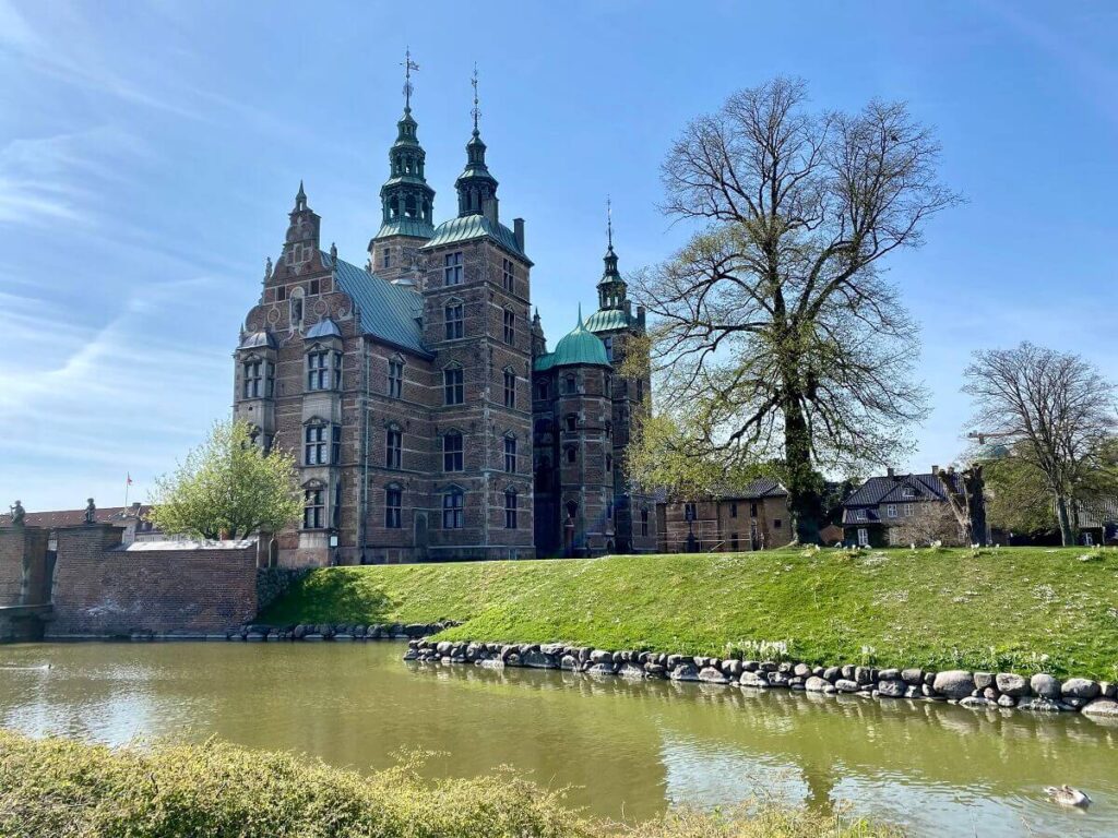View of Rosenborg Castle across a muddy brown moat