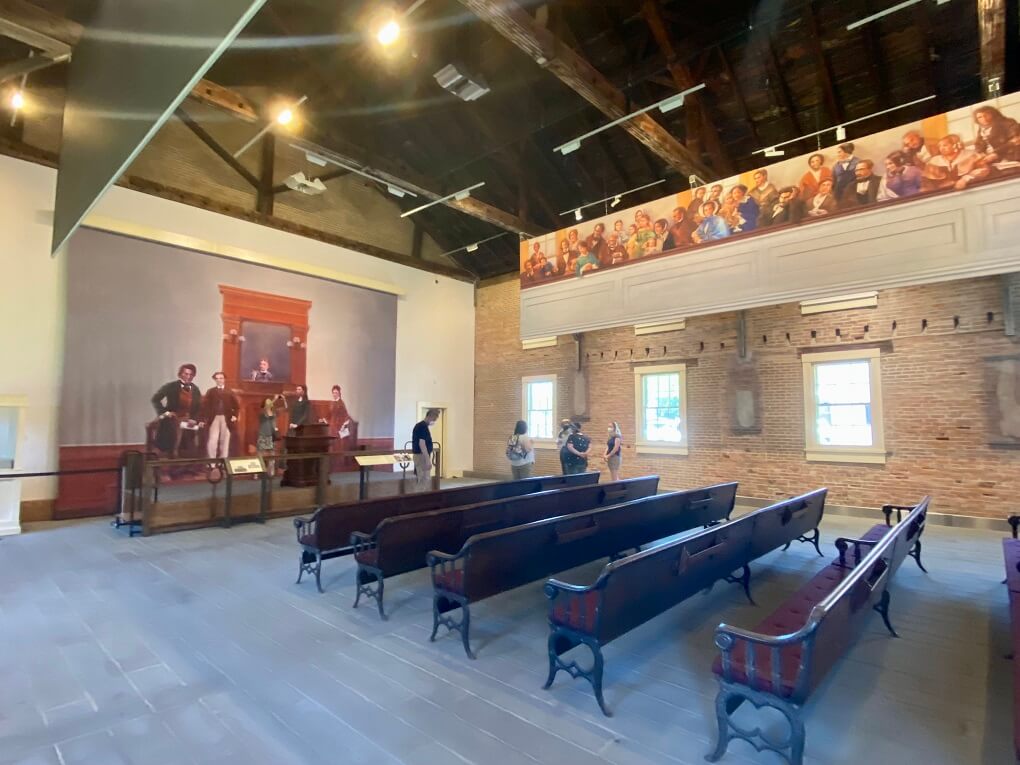 The interior of the Wesleyan Chapel with hanging murals depicting historic events